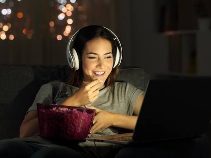 Girl Watching Shows on Laptop OTT Millennial popcorn bl on campus